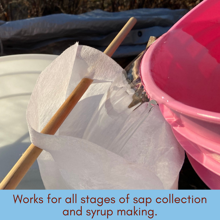 Large pink bucket pouring clear sap through one filter into another large white bucket. Caption reads: "works for all stages of sap collection and syrup making".